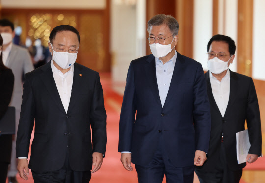 문재인(가운데) 대통령이 7일 청와대 본관에서 열린 한국판 뉴딜 격려 오찬 간담회에 참석하기 위해 홍남기(왼쪽) 경제부총리 겸 기획재정부 장관, 유영민(오른쪽) 대통령비서실장과 함께 행사장으로 향하고 있다. 연합뉴스